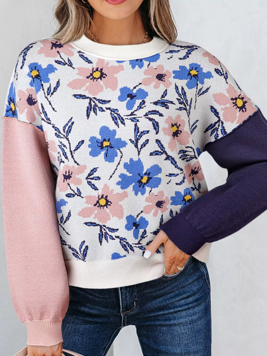 Floral patterned sweater with pink and purple sleeves on a plain background