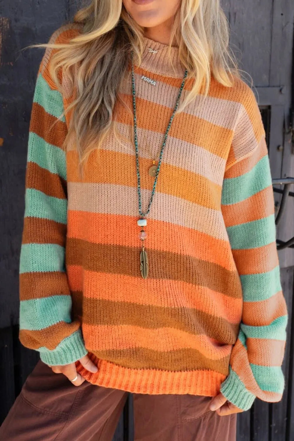 Person wearing a striped sweater with orange, green, and brown colors.