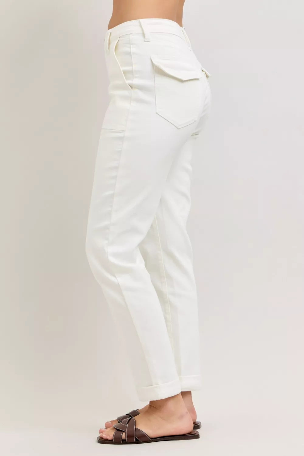 White pants worn by a person on a plain background