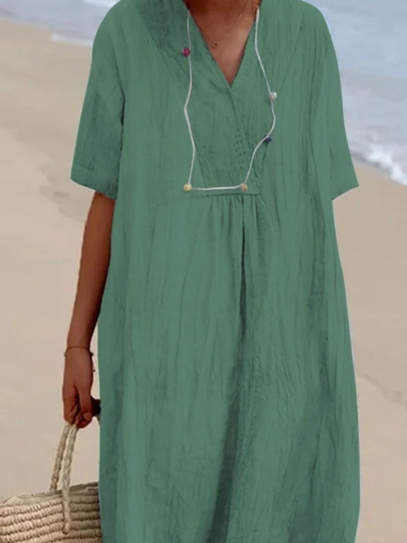 Person wearing a green dress on a beach