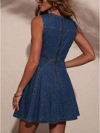 Woman wearing a blue denim dress against a neutral background