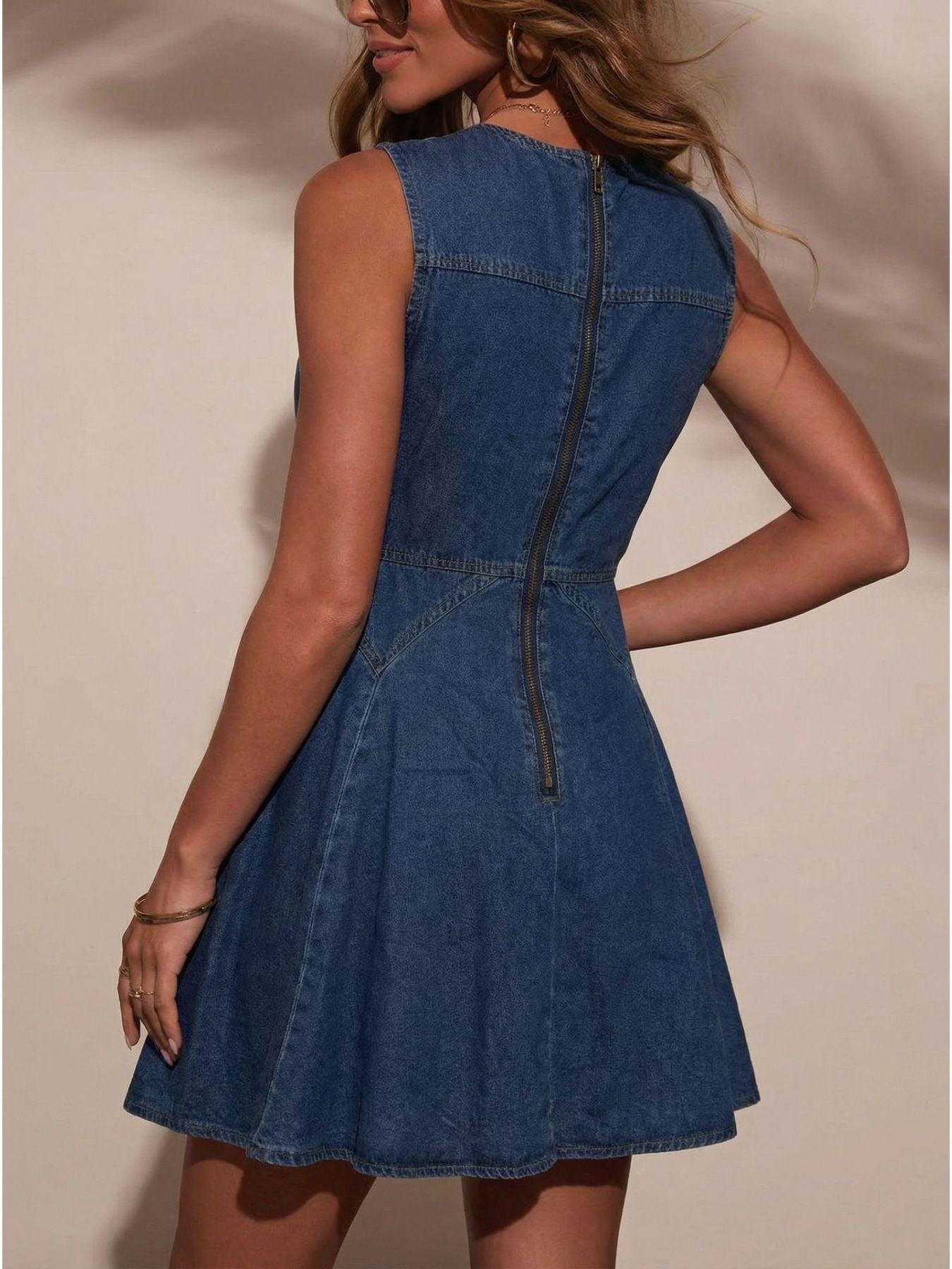 Woman wearing a blue denim dress against a neutral background
