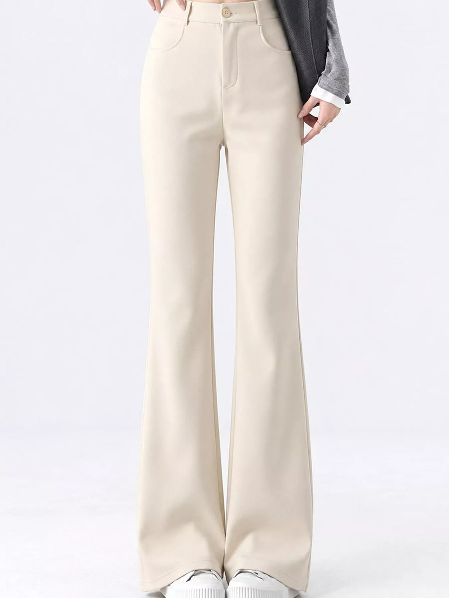 A person wearing high-waisted, light beige wide-leg pants with a gray blazer and white sneakers, shown from the waist down against a plain white studio background.