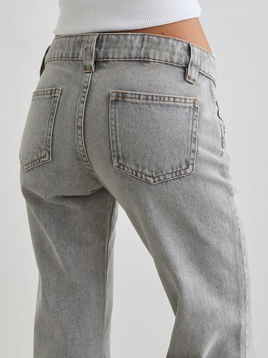 Gray jeans being worn on a plain background