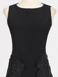Black sleeveless dress with floral appliqués on a mannequin against a white background
