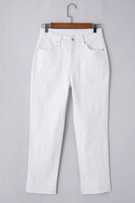 White jeans on a hanger against a gray background