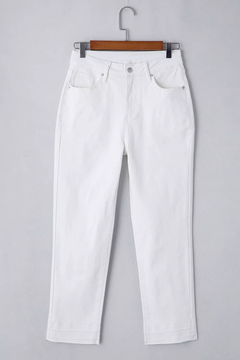 White jeans on a hanger against a gray background