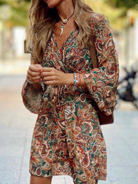 Woman wearing a patterned dress with a blurred outdoor background