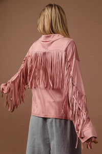 Person wearing a pink fringed jacket against a brown background