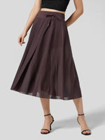 Person wearing a dark brown skirt on a light gray background