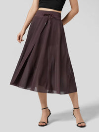 Person wearing a dark brown skirt on a light gray background