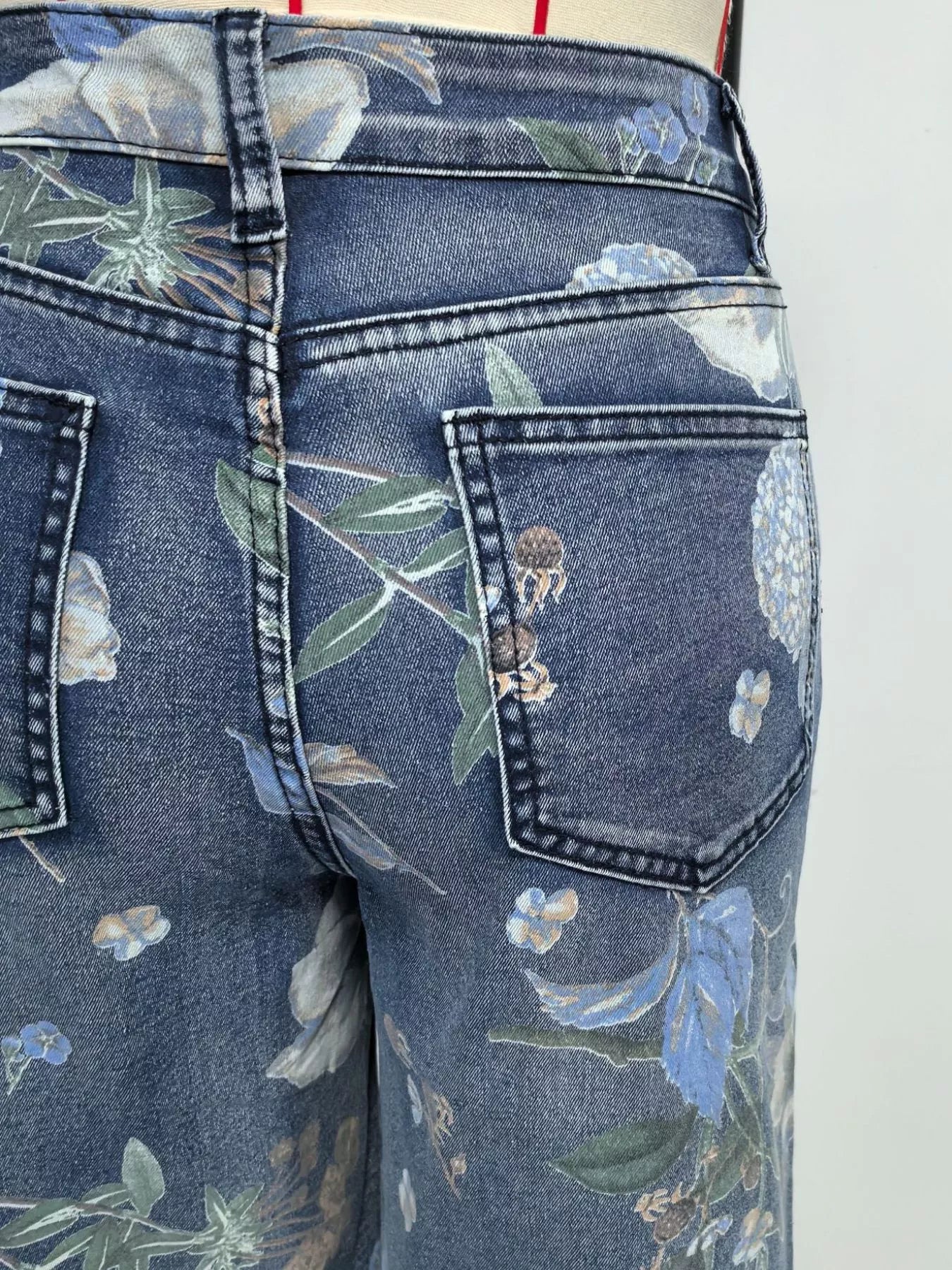 Floral-patterned jeans with a focus on the pocket area.