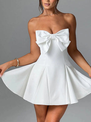White strapless dress with a large bow detail on a gray background
