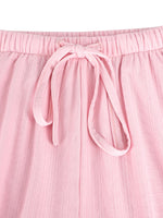 Close-up of pink pants with a tie waist on a white background