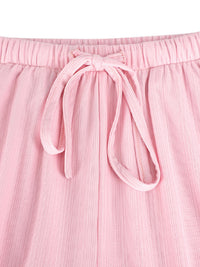 Close-up of pink pants with a tie waist on a white background