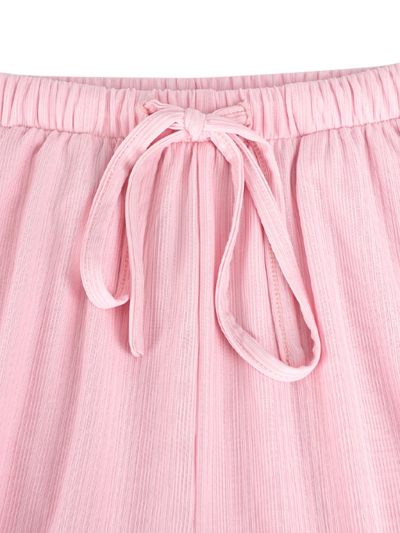 Close-up of pink pants with a tie waist on a white background