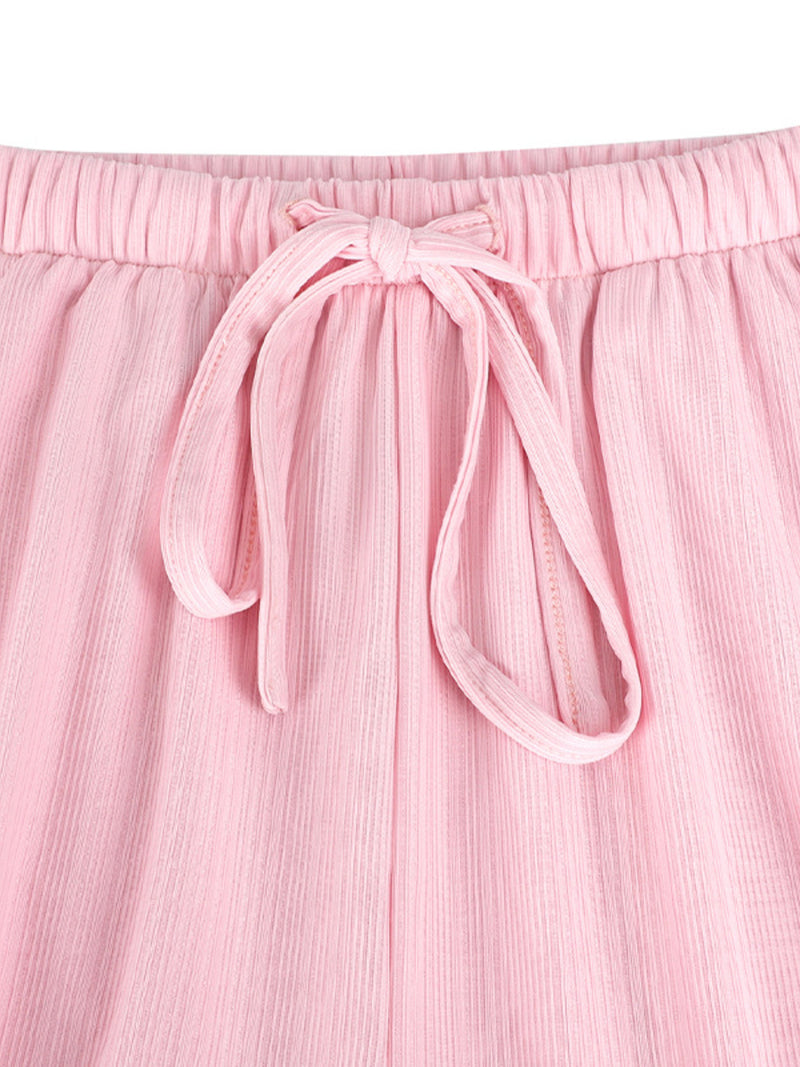 Close-up of pink pants with a tie waist on a white background