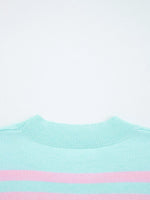 Close-up of a light blue sweater with a pink stripe on a white background