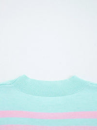 Close-up of a light blue sweater with a pink stripe on a white background