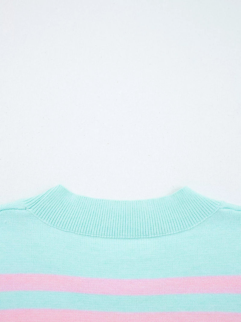 Close-up of a light blue sweater with a pink stripe on a white background