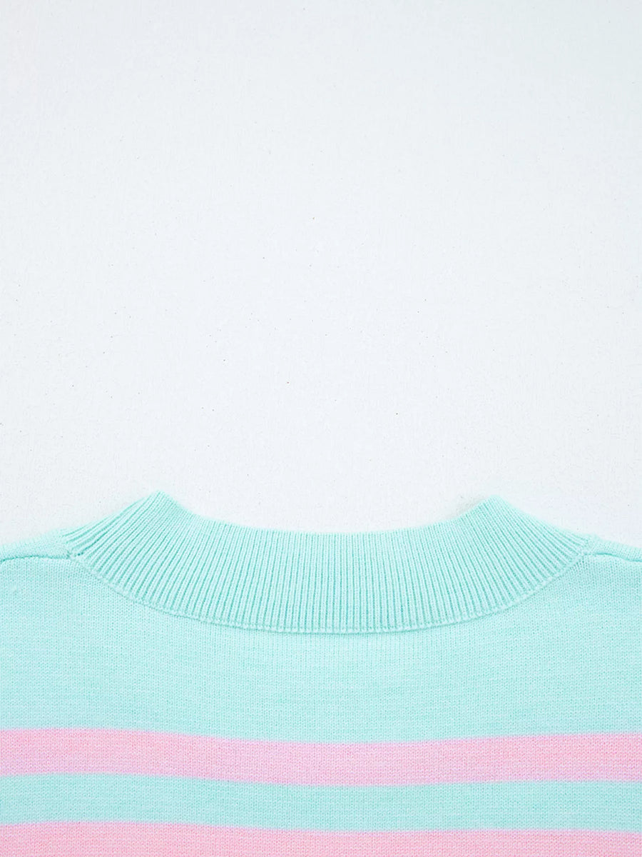 Close-up of a light blue sweater with a pink stripe on a white background