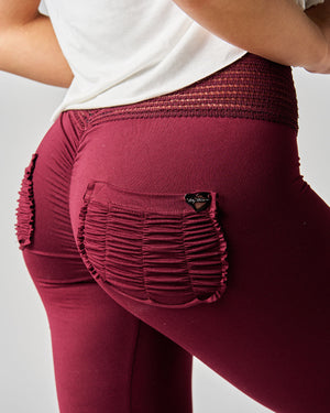 Maroon leggings with textured waistband and pocket on a plain background