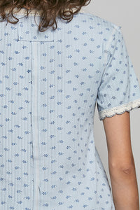 Light blue floral patterned shirt worn by a person with a neutral background