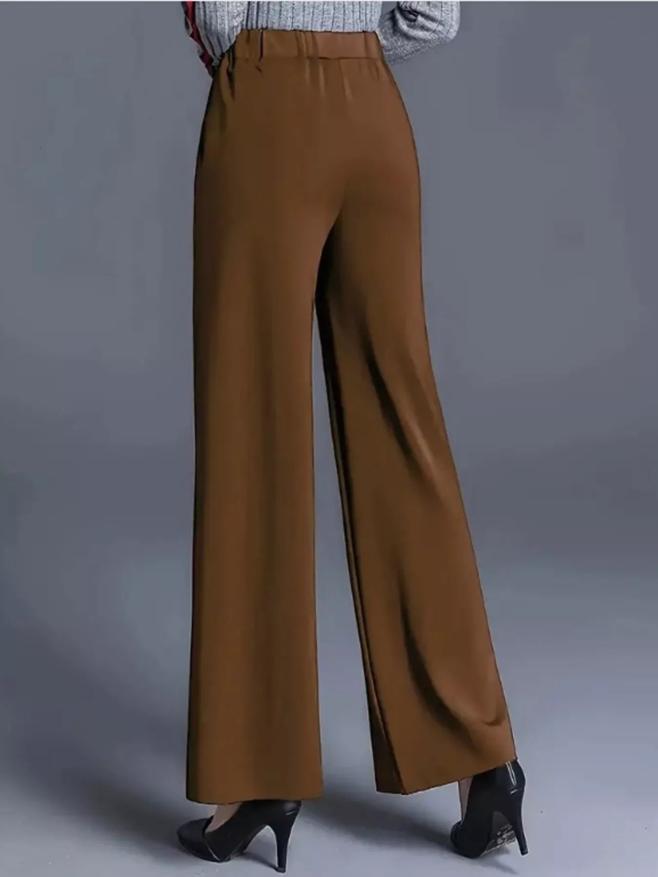 Brown wide-leg pants worn by a person on a gray background
