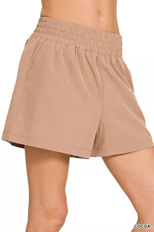 Beige shorts worn by a person on a white background