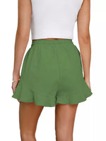 Green shorts worn by a person on a white background