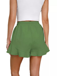 Green shorts worn by a person on a white background