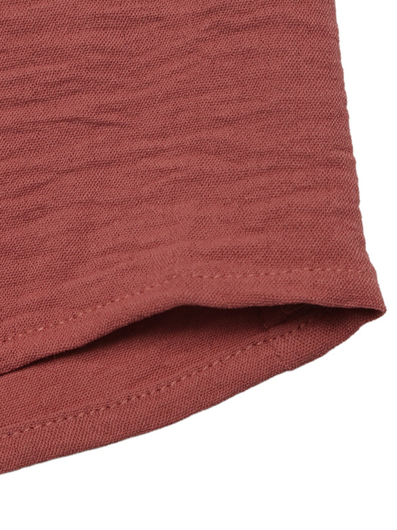 Close-up of a folded terracotta-colored fabric on a white background