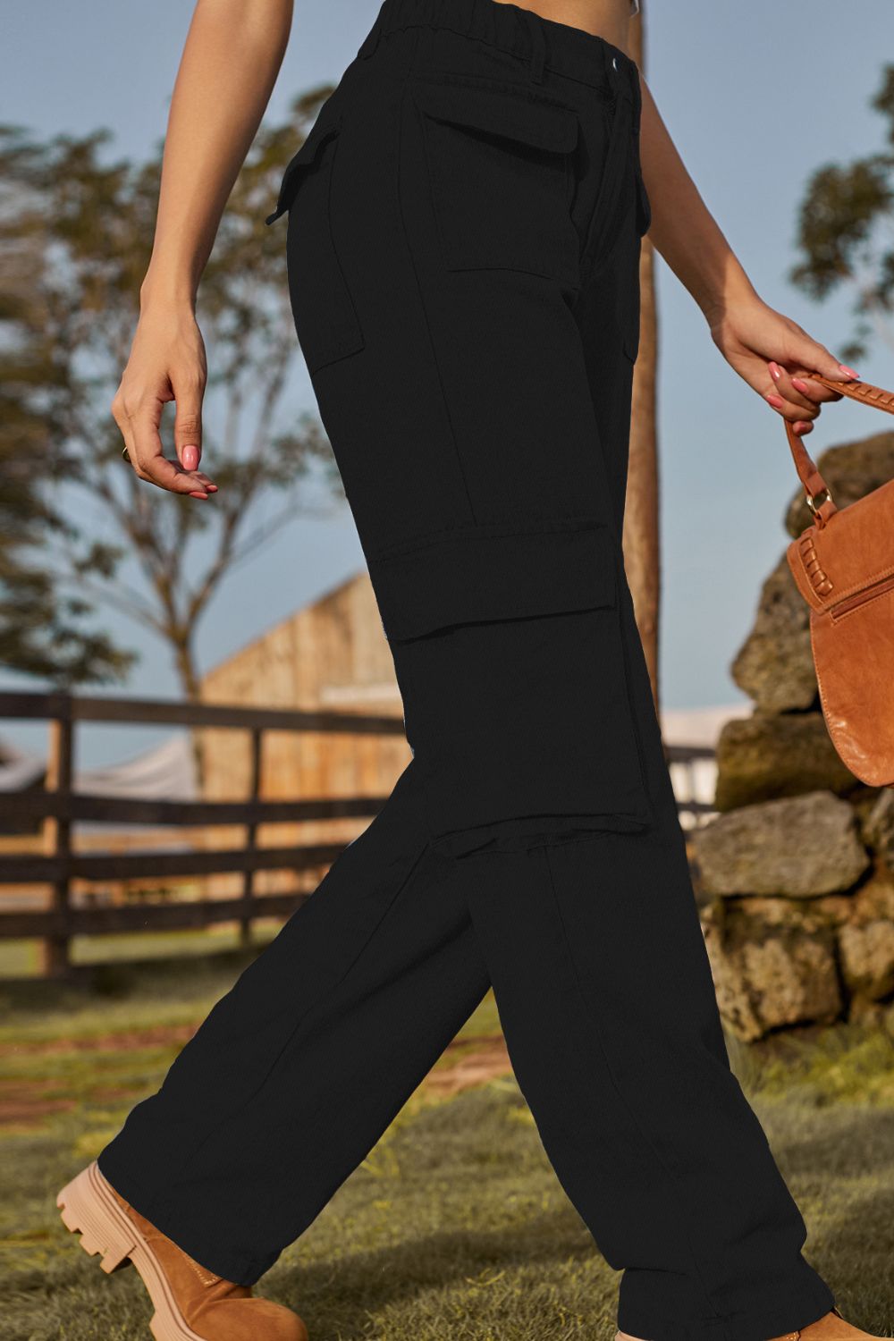 Person wearing black pants walking outdoors with a rustic background