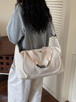Person holding a beige tote bag indoors