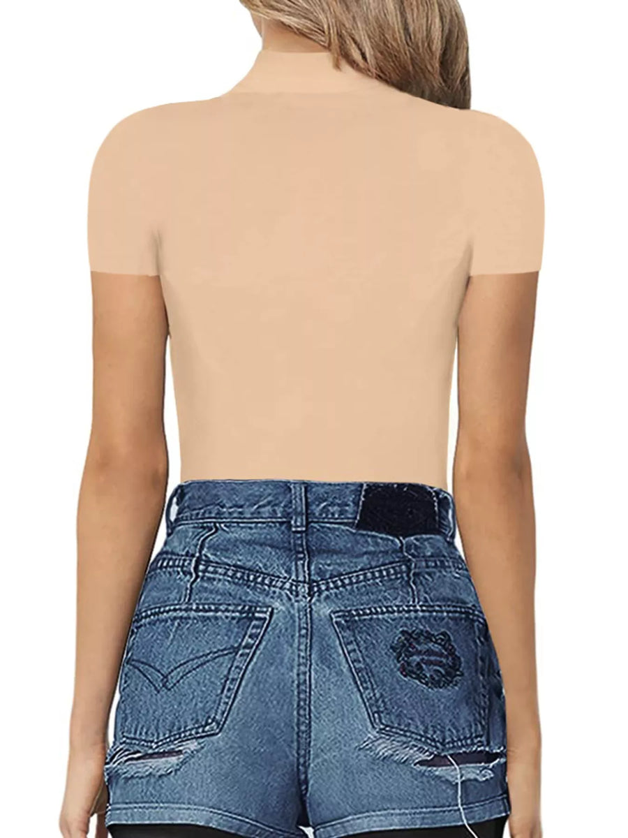 Person wearing a beige top and blue denim shorts on a white background