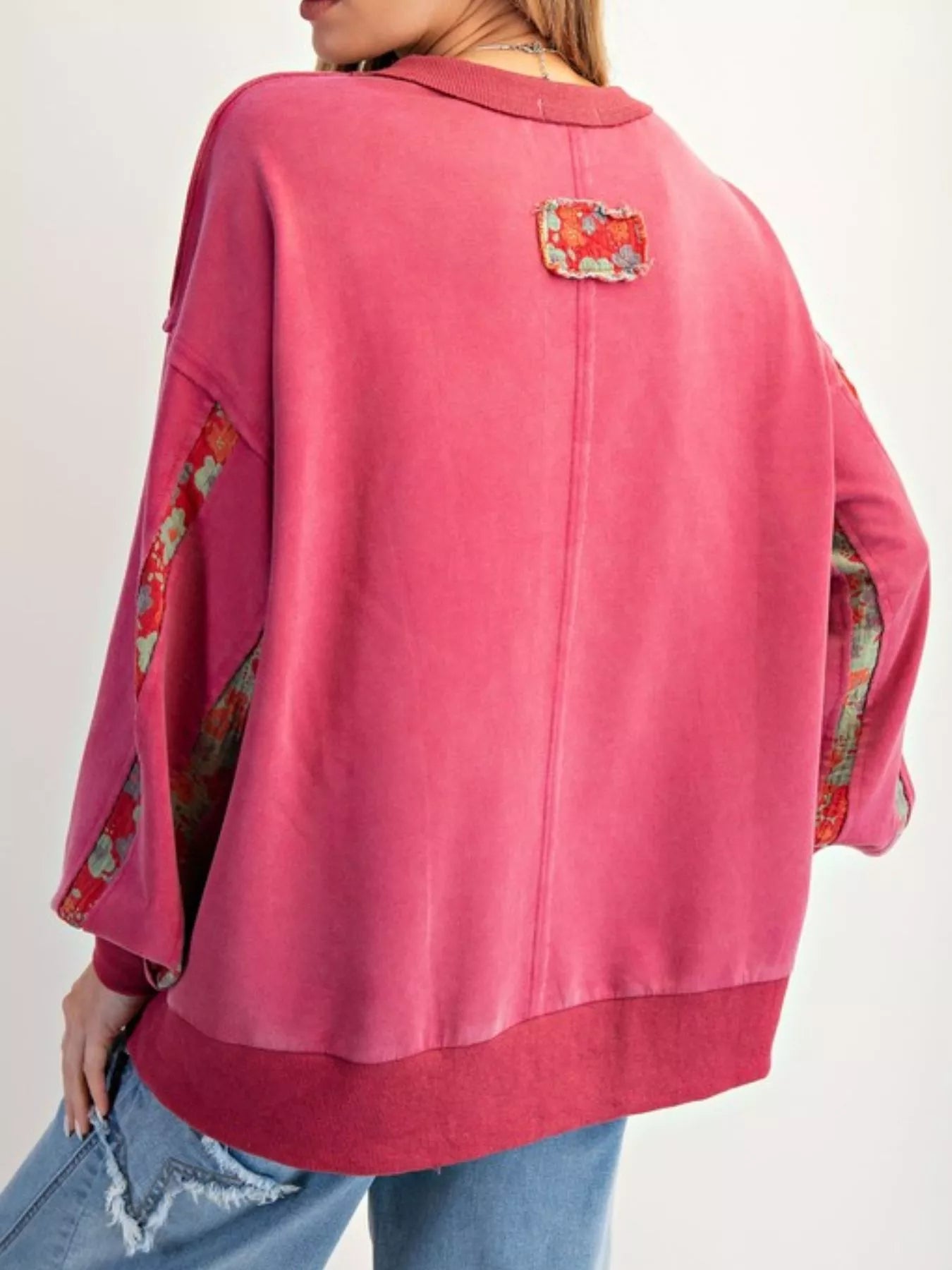 Pink jacket with floral patterns on sleeves and back against a white background