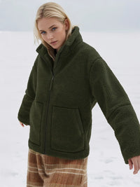Woman wearing a green fleece jacket in a snowy landscape