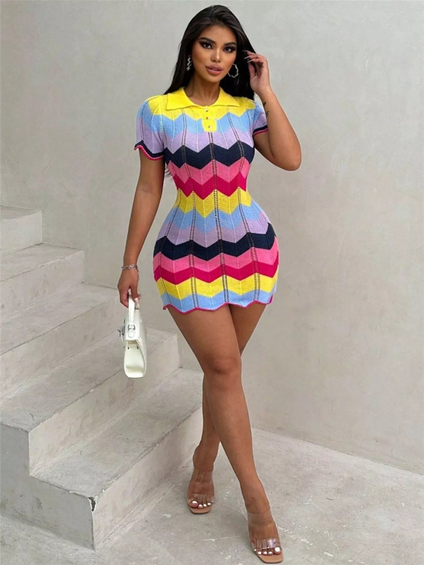 Woman wearing a colorful striped dress standing on a staircase.