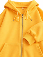 A close-up of a bright yellow zip-up hoodie with a front zipper, drawstrings, and ribbed cuffs, shown against a plain white background.