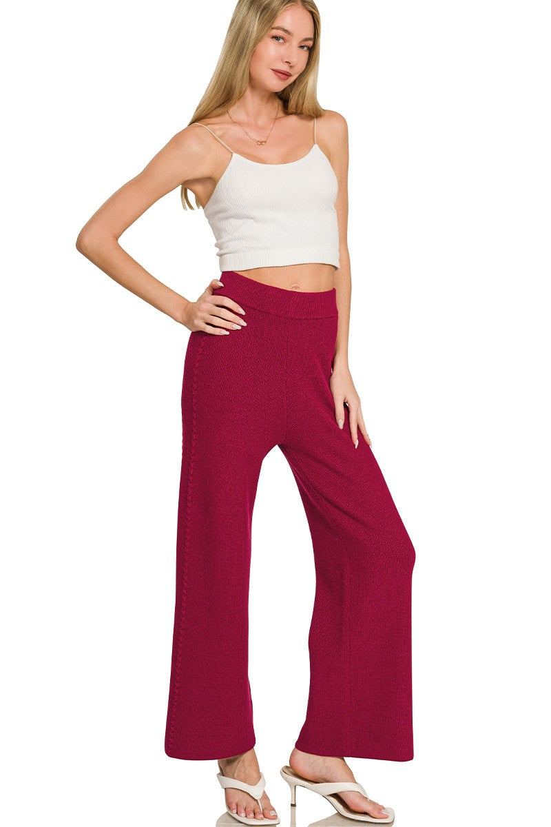Woman wearing a white top and red pants on a white background