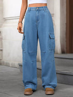Person wearing blue cargo pants standing on a sidewalk.