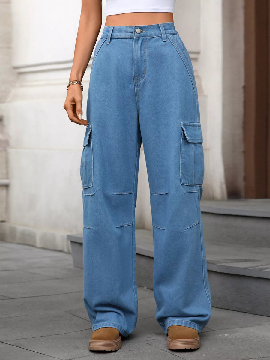 Person wearing blue cargo pants standing on a sidewalk.