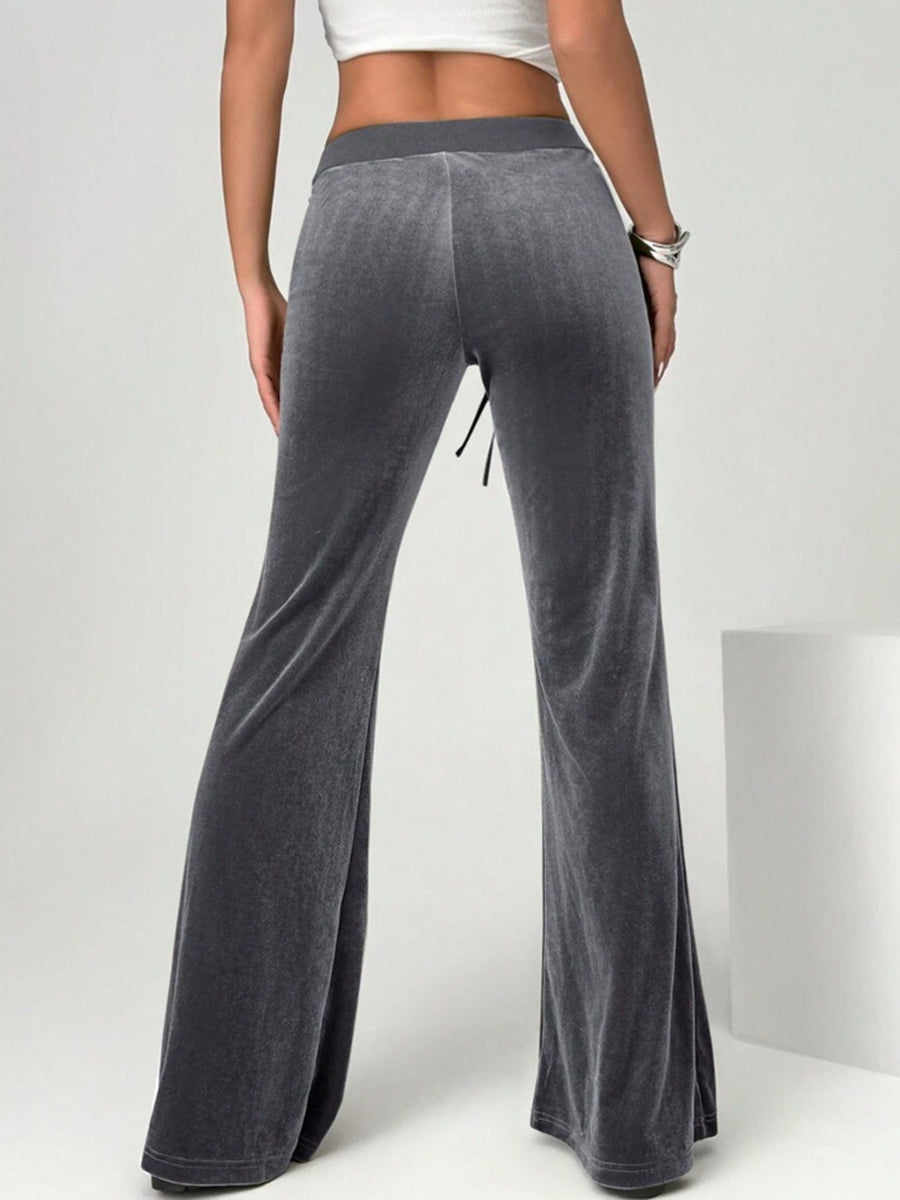 Gray flared pants worn by a person on a white background