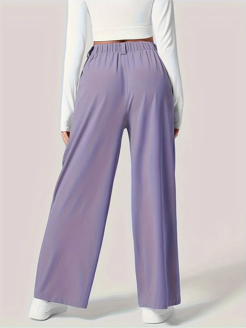 Person wearing lavender wide-leg pants on a light pink background