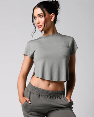 A person wearing a pink t-shirt with a front right pocket, paired with matching pink shorts.