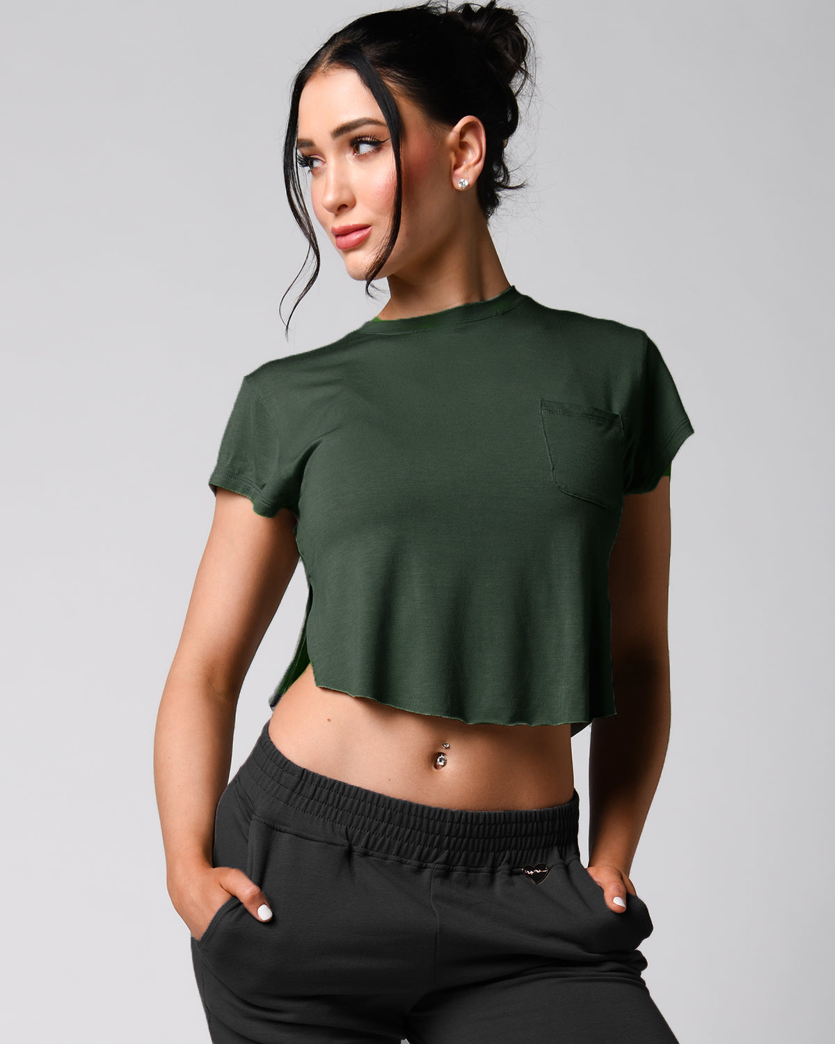 A person wearing a pink t-shirt with a front right pocket, paired with matching pink shorts.