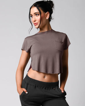 A person wearing a pink t-shirt with a front right pocket, paired with matching pink shorts.