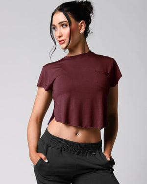 A person wearing a pink t-shirt with a front right pocket, paired with matching pink shorts.