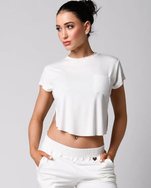 A person wearing a pink t-shirt with a front right pocket, paired with matching pink shorts.