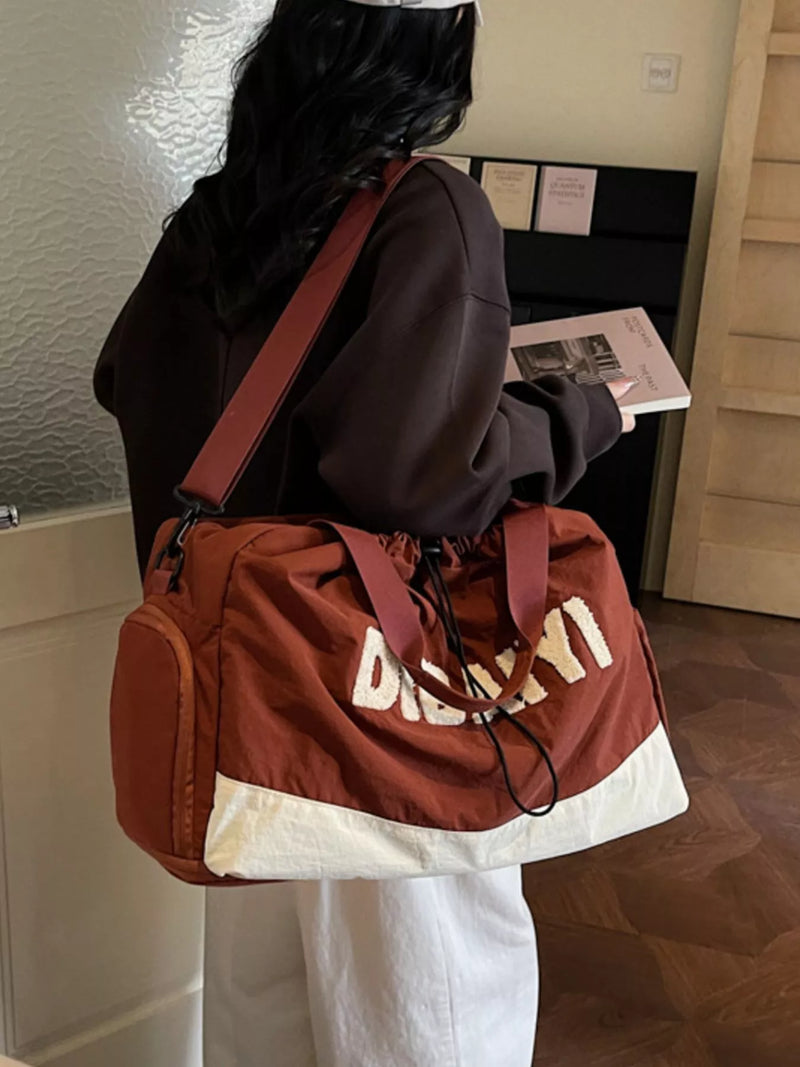 Person wearing a brown duffel bag with 'Duckn' branding in a room.
